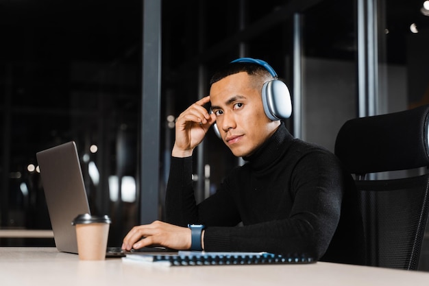 Hombre asiático sosteniendo su cabeza y pensando en trabajar en línea en una computadora portátil Hombre guapo preocupado por el trabajo remoto