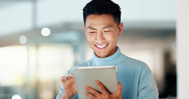 Hombre asiático con tableta sonrisa y desplazarse pensando y leyendo correo electrónico revisión o artículo en la investigación de Internet de puesta en marcha y hombre de negocios feliz con aplicación digital para con redes sociales o web