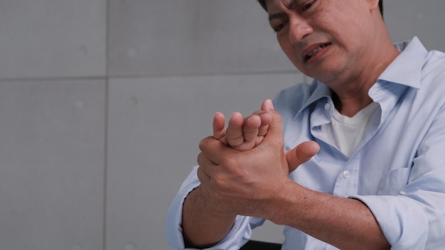 Foto un hombre asiático tiene hormigueo y entumecimiento en la mano que causa beriberi