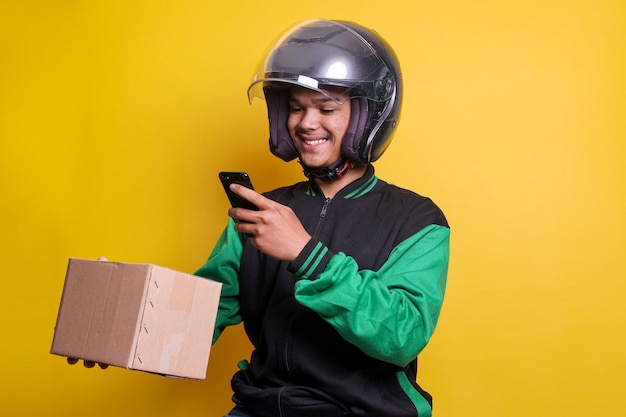 Un hombre asiático trabaja como mensajero comercial de entrega de motocicletas escaneando el código de barras en el paquete