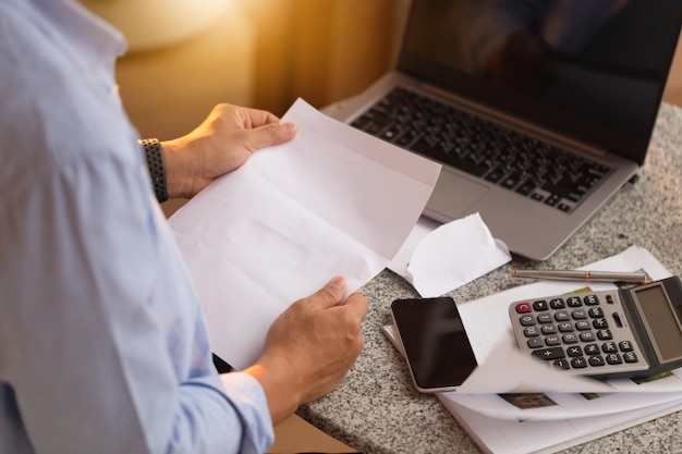 Hombre asiático trabajando con documentos y hombre portátil revisando sus facturas