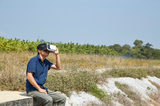 Hombre asiático usando el casco de realidad virtual