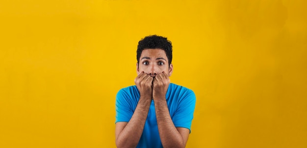 Hombre asustado aislado sobre fondo amarillo. Hombre negro guapo con camisa azul sobre amarillo.