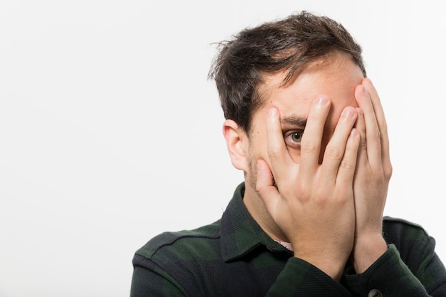 Foto hombre asustado que cubre la cara