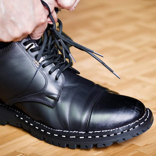 Foto un hombre se ata los cordones de los zapatos en el suelo.