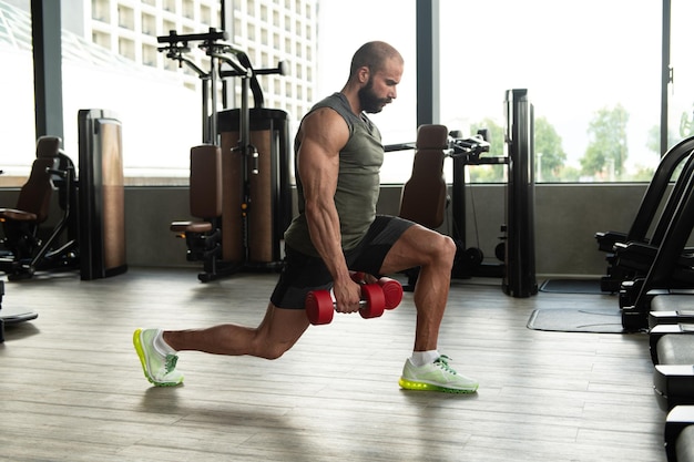 Hombre atleta ejercitando glúteos con mancuerna