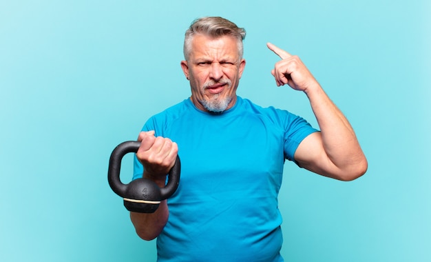 Hombre atleta senior que se siente confundido y desconcertado, mostrando que está loco, loco o loco