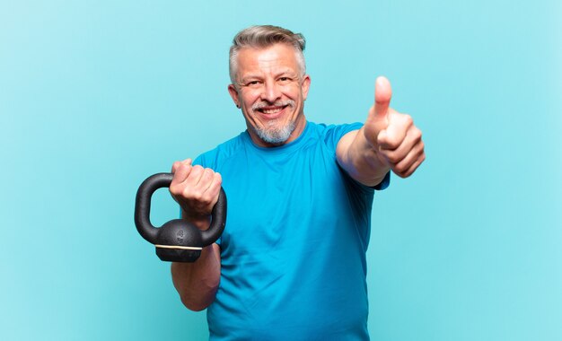 Hombre atleta senior que se siente orgulloso, despreocupado, seguro y feliz, sonriendo positivamente con los pulgares hacia arriba