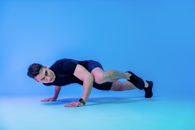 Hombre atlético con cuerpo musculoso en forma entrenando en el estudio