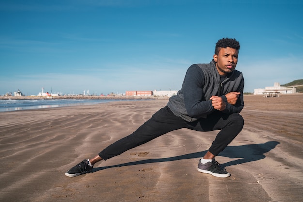 Hombre atlético estirando las piernas antes del ejercicio