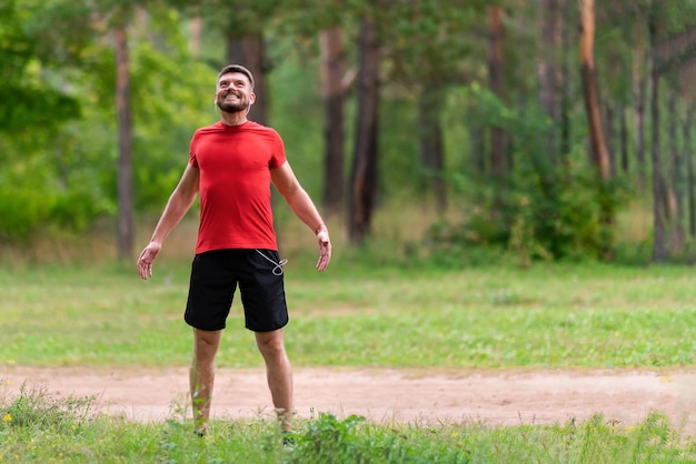 Hombre atlético joven que se extiende al aire libre