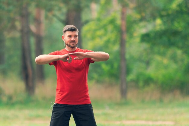 Hombre atlético joven que se extiende al aire libre