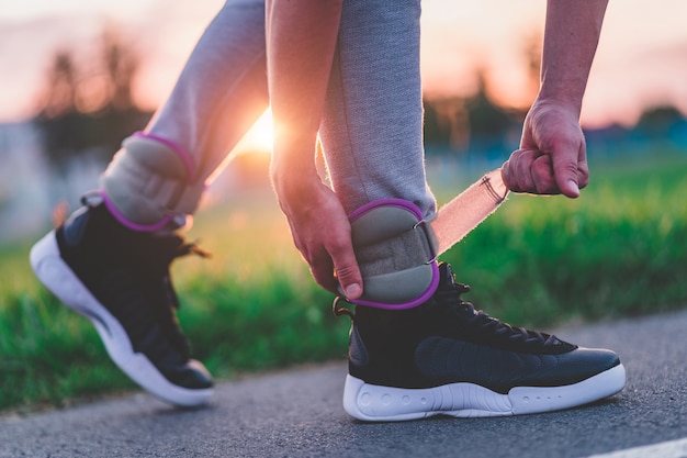 Hombre atlético pone pesas deportivas para caminar durante el entrenamiento al aire libre. Estilo de vida saludable y deportivo.