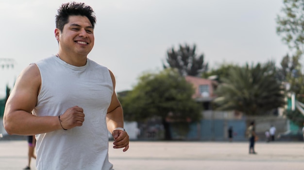 Hombre atlético sonriendo, trotando en un barrio latino.