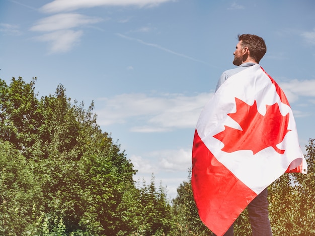 Hombre atractivo con bandera canadiense. fiesta Nacional