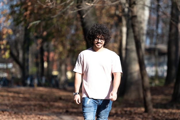 Hombre atractivo caminando en el bosque de otoño