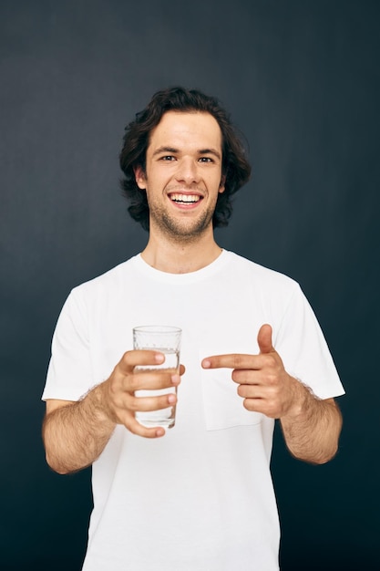 Hombre atractivo en una camiseta blanca vaso de agua Estilo de vida inalterado