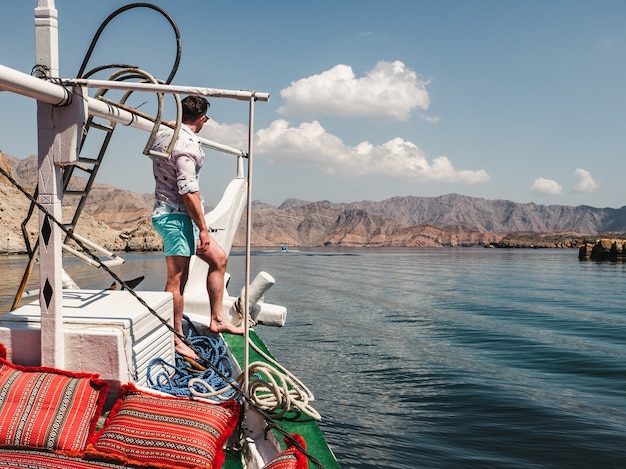 Hombre atractivo, de moda de pie en un barco.