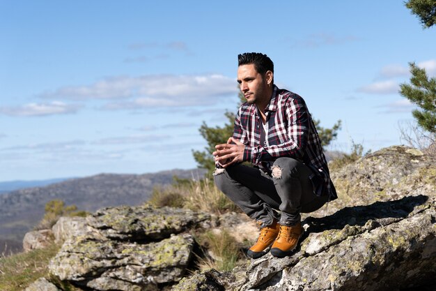 Hombre atractivo en la montaña mirando el paisaje