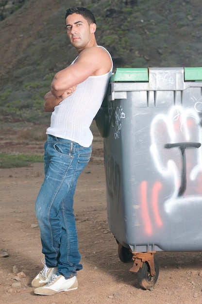 Hombre atractivo y musculoso en una zona urbana con graffiti