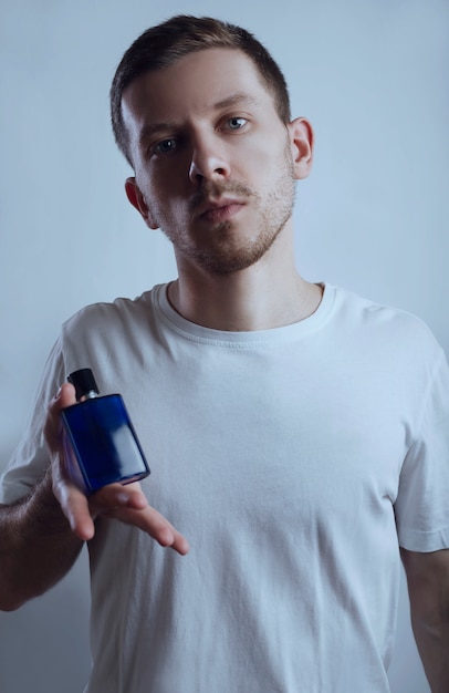 Hombre atractivo y perfume en azul