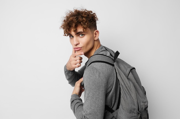 Hombre atractivo posando con un estilo de vida universitario de mochila inalterado