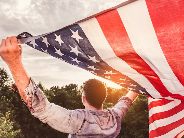 Hombre atractivo que sostiene la bandera de los Estados Unidos