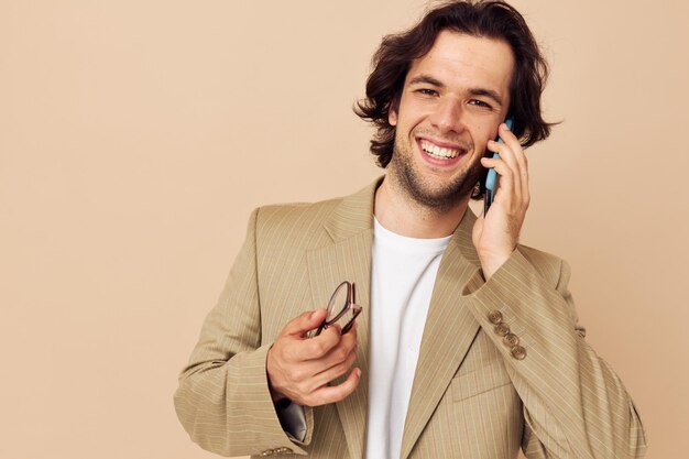Hombre atractivo en un traje que presenta emociones hablando por teléfono estilo de vida inalterado