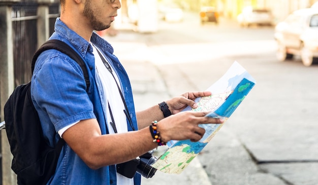 Hombre desde atrás mirando un mapa en busca de un concepto de viaje y turismo de ubicación