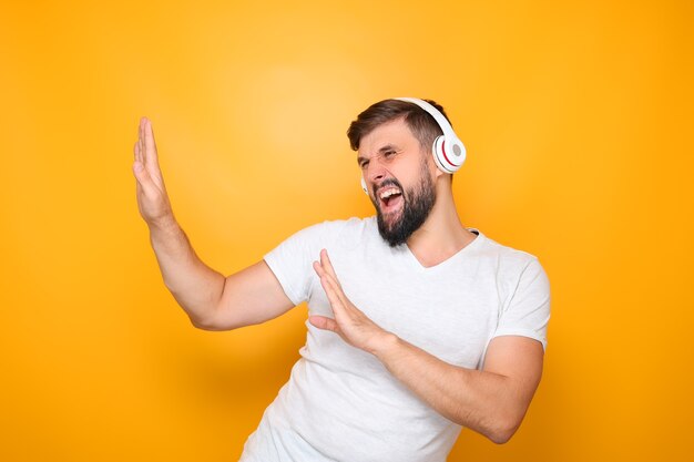 Un hombre con auriculares escucha música y grita.