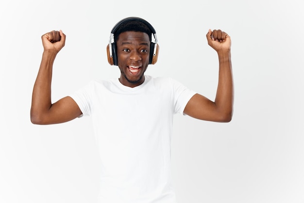 Hombre con auriculares escuchando música gesticulando con las manos fondo claro