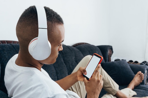 Hombre con auriculares inalámbricos sosteniendo un espacio de copia de teléfono móvil horizontal