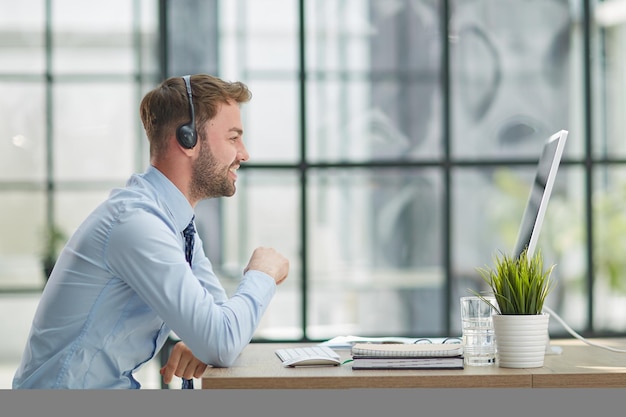 Hombre con auriculares y portátil trabajando en la oficina