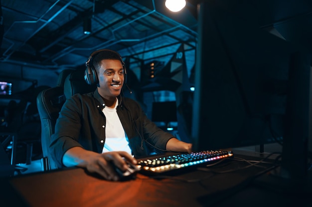 Foto un hombre con auriculares se sienta en una computadora y reacciona activamente al juego foto de alta calidad
