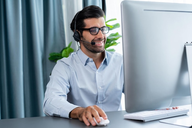 Un hombre con auriculares se sienta frente a una computadora.
