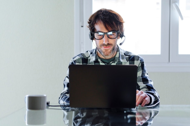 Hombre con auriculares teletrabajo desde casa