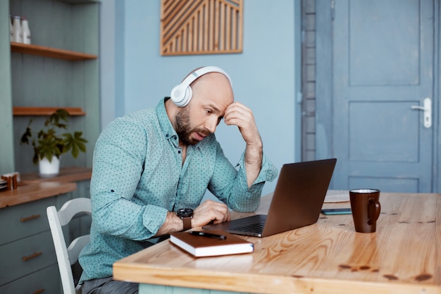 Un hombre con auriculares verifica los resultados del trabajo del día anterior.