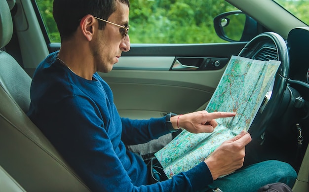 El hombre en el auto mira el mapa