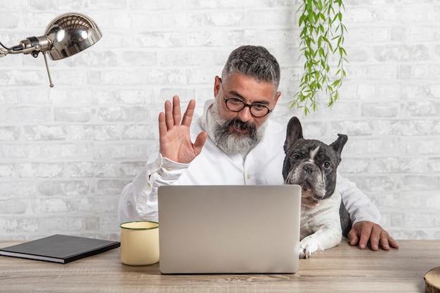 Hombre autónomo que trabaja desde casa con su perro. Entrar en una reunión con un lindo perro