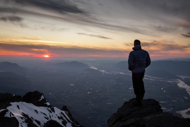 Hombre aventurero en la cima de la montaña