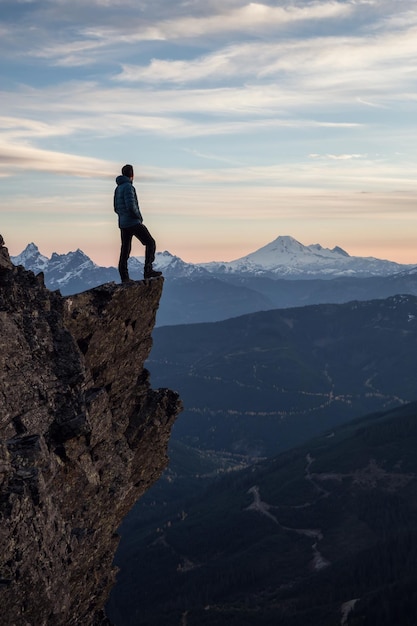 Foto hombre aventurero en la cima de la montaña