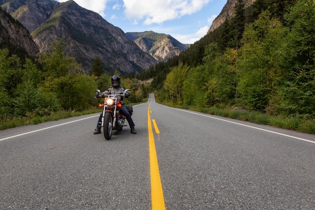 Hombre aventurero en una motocicleta disfrutando del paisaje canadiense