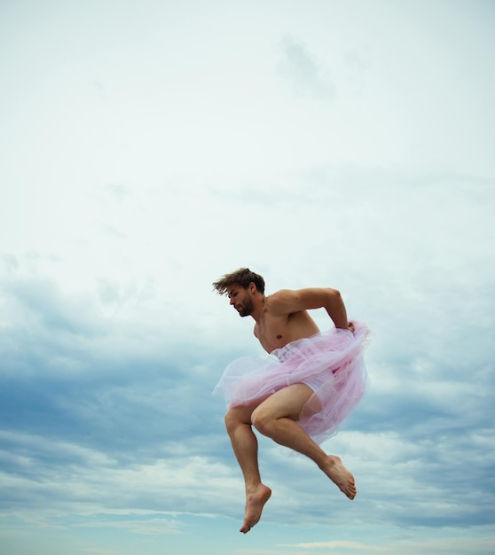 Hombre bailando en tutu en estudio de ballet. Bailarina loca. drag queen Hombre con falda de bailarina al aire libre. Fanático del hombre divertido. Inspiración y sueños. sensación de libertad. El hombre salta sobre el fondo del cielo.