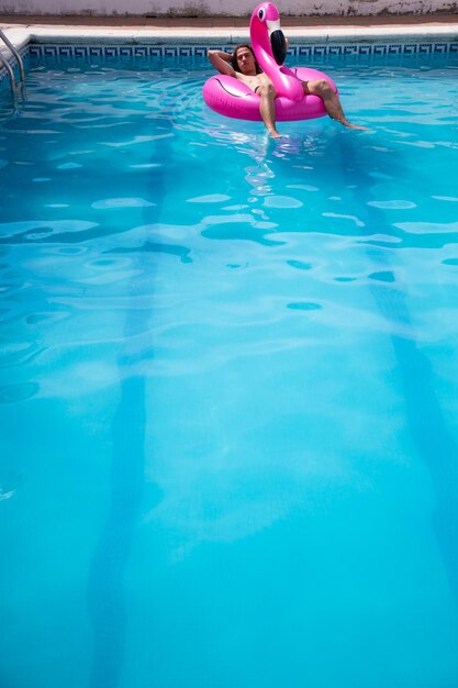 Foto hombre en balsa inflable nadando en la piscina.