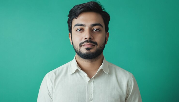 un hombre con barba y una camisa blanca que dice que está posando para una foto