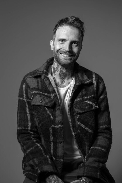 Foto un hombre con barba y camisa blanca sonríe a la cámara.