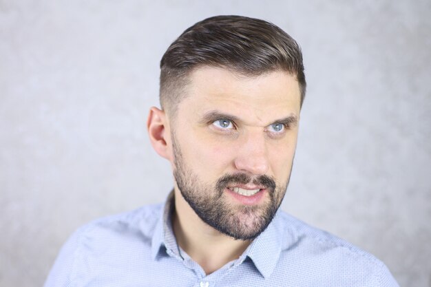 un hombre con barba en una camisa hace gestos con los dedos