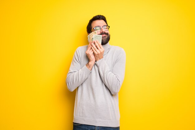 Hombre con barba y cuello alto tomando mucho dinero