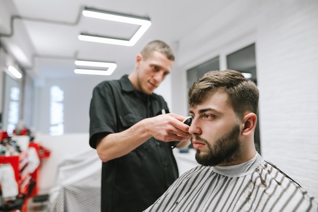 Hombre con barba y cuidado del cabello en barbería