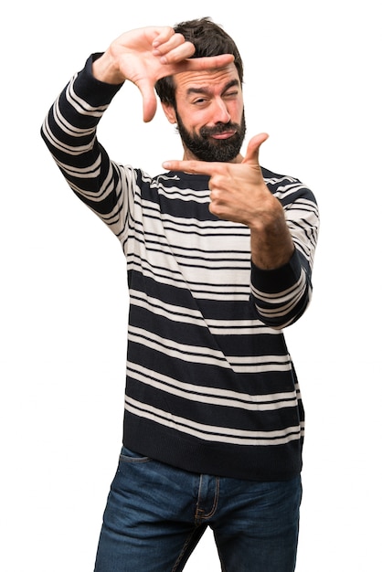 Foto hombre con barba enfocando con sus dedos